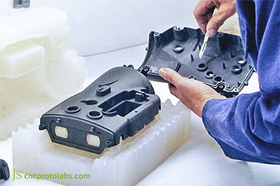 Ispezione manuale di un pezzo stampato in plastica.