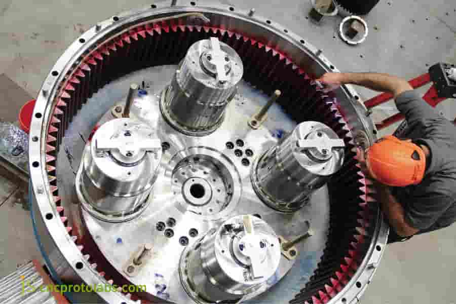 A worker inspecting a large metal gear.